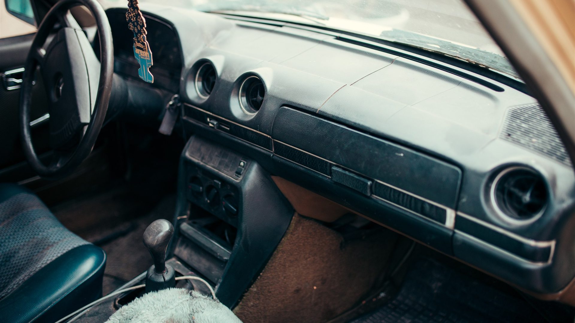 Classic car interior with worn dashboard and upholstery before restoration
